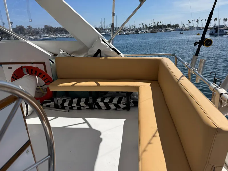 Slide: The Image of 1981 Bertram 58 Flybridge Motor Yacht with tan seating, overlooking marina. - 33