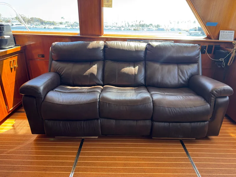 Slide: The Image of Luxurious leather sofa inside a 1981 Bertram 58 Flybridge Motor Yacht, with wooden flooring. - 4