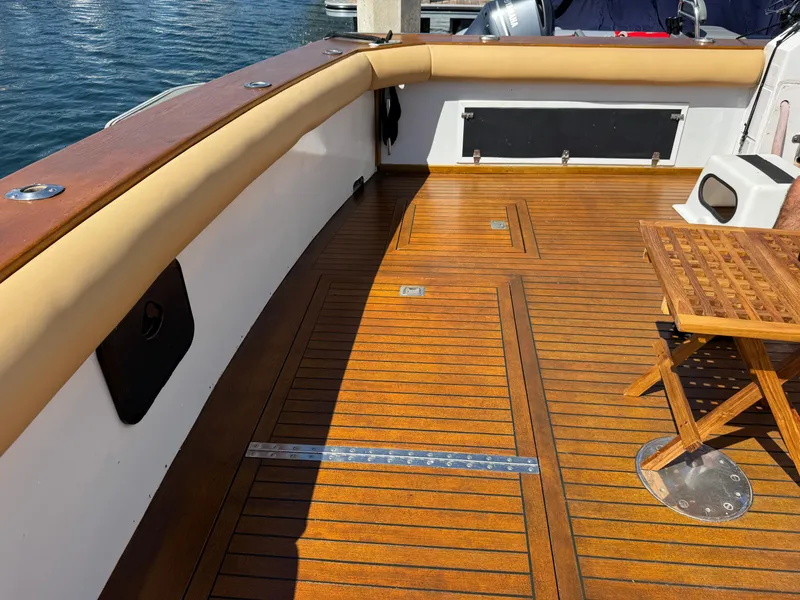 Slide: The Image of 1981 Bertram 58 Flybridge Motor Yacht deck with wooden flooring and seating area. - 41