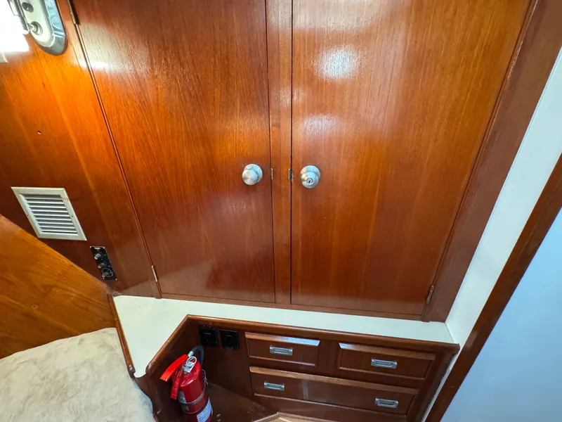 Slide: The Image of Wooden cabinetry and fire extinguisher inside 1981 Bertram 58 Flybridge Motor Yacht interior. - 42