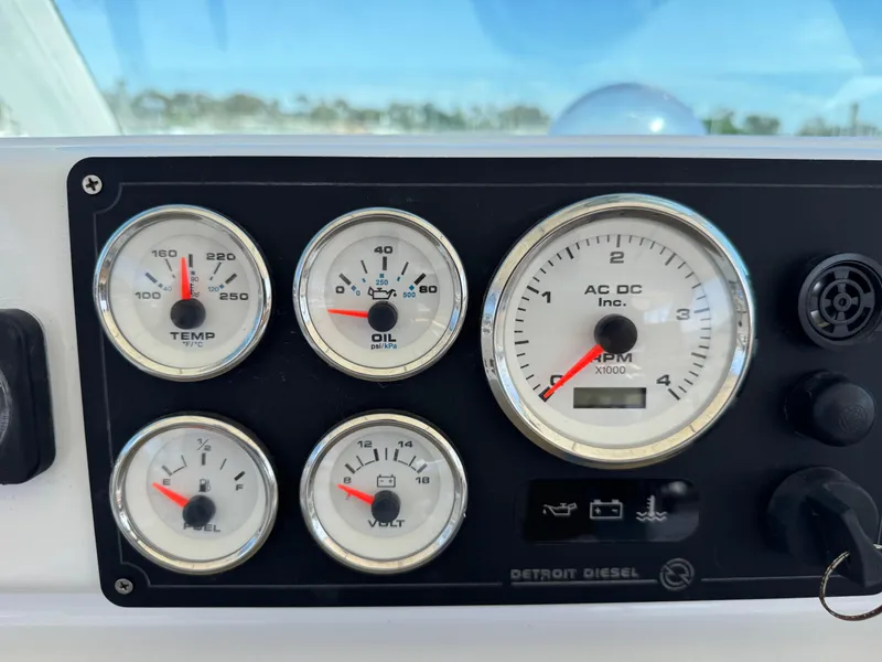 Slide: The Image of Instrument panel of a 1981 Bertram 58 Flybridge Motor Yacht, featuring gauges for temperature, oil, RPM, fuel, and voltage. - 44