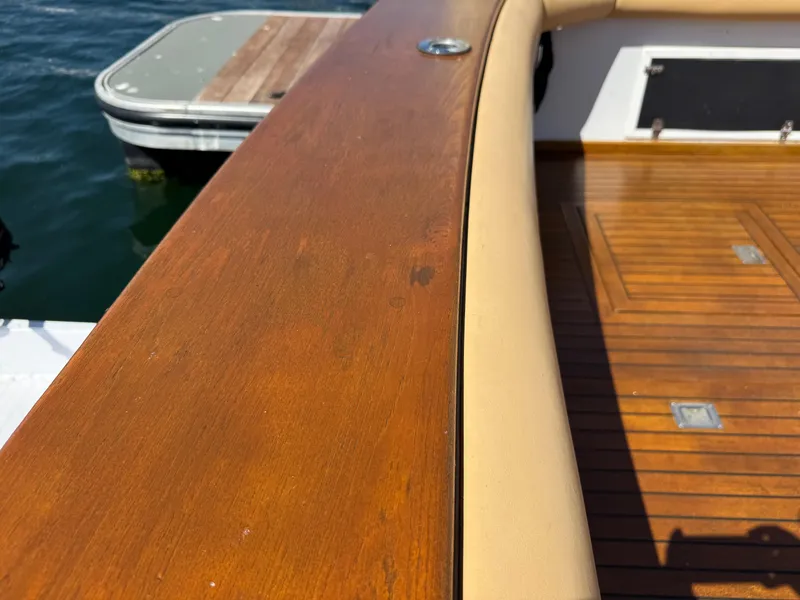 Slide: The Image of 1981 Bertram 58 Flybridge Motor Yacht deck with polished wood and water view. - 47