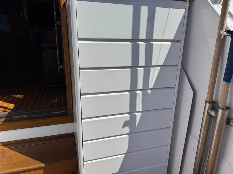 Slide: The Image of White paneling on 1981 Bertram 58 Flybridge Motor Yacht, with shadows and wooden interior. - 49