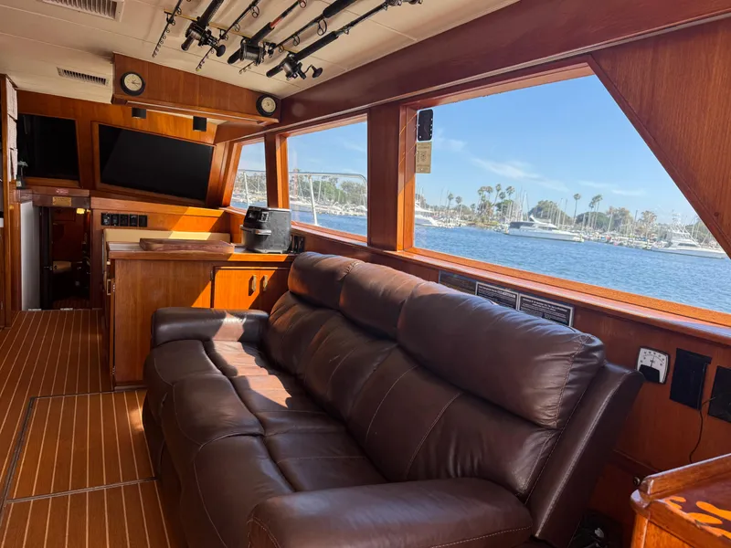 Slide: The Image of Luxurious interior of 1981 Bertram 58 Flybridge Motor Yacht with leather sofa and scenic window view. - 5