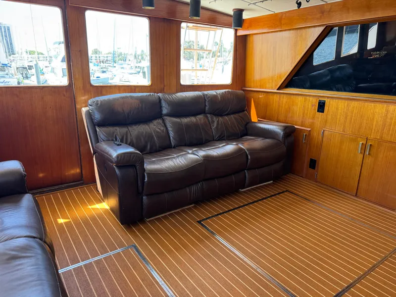 Slide: The Image of Interior of 1981 Bertram 58 Flybridge Motor Yacht with leather sofas and wooden paneling. - 6