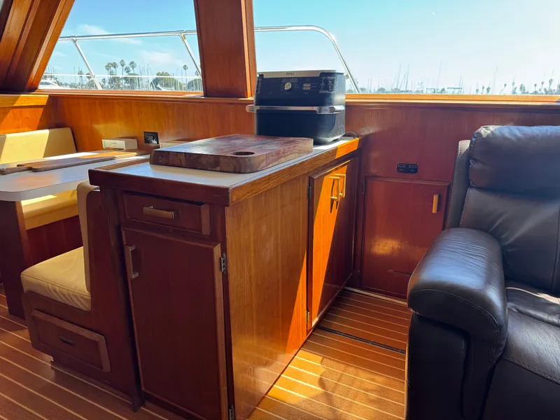 Slide: The Image of Interior of 1981 Bertram 58 Flybridge Motor Yacht with wooden cabinetry and leather seating. - 8