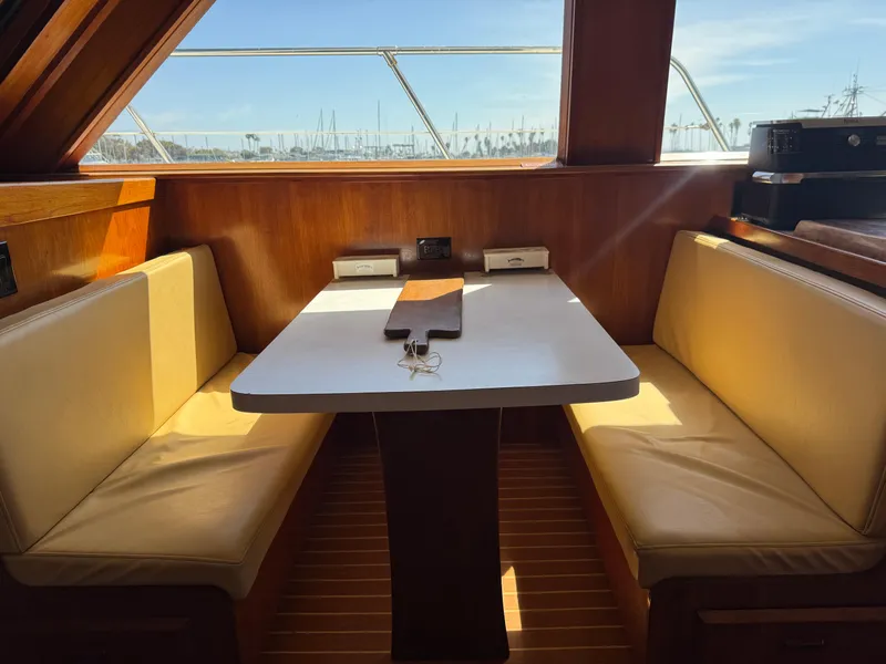 Slide: The Image of Interior of 1981 Bertram 58 Flybridge Motor Yacht with dining area and window view. - 9