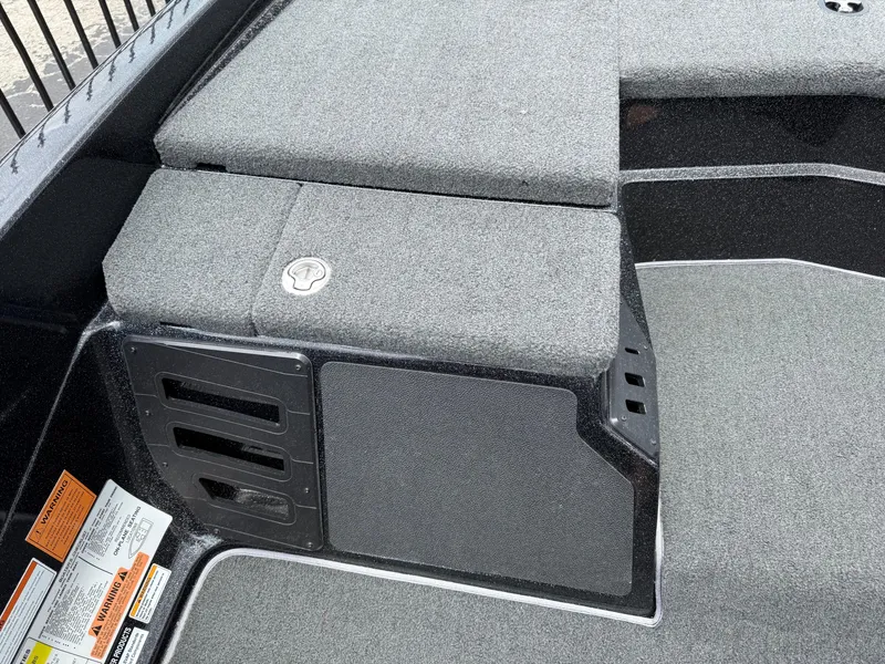 Slide: The Image of 2022 Skeeter ZX 150 boat interior with carpeted storage compartments and safety labels. - 24