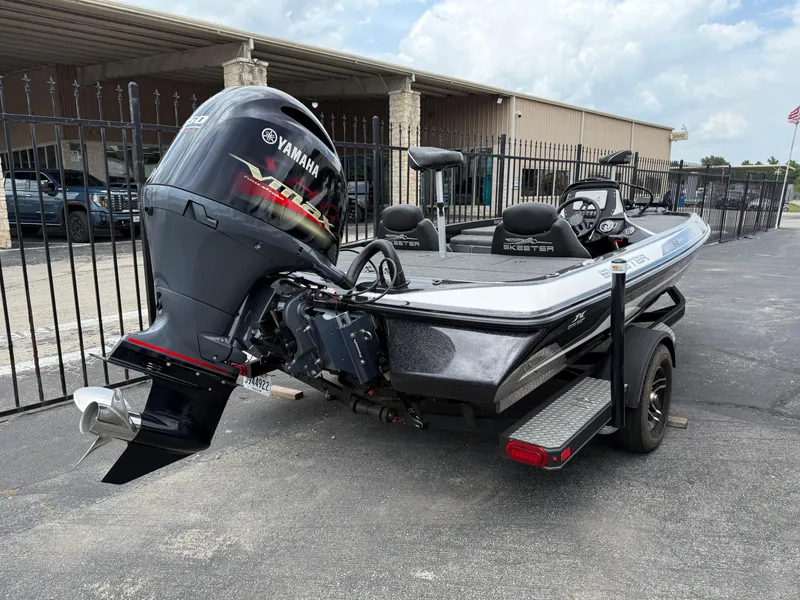 Slide: The Image of 2022 Skeeter ZX 150 boat with Yamaha engine, parked on a trailer near a building. - 4