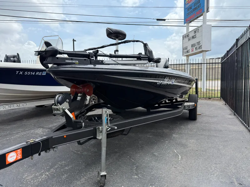 Slide: The Image of 2022 Skeeter ZX 150 boat on trailer, parked outdoors near dealership sign. - 8