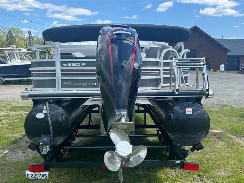 Slide: The Image of 2022 Ranger 220 F pontoon boat with Mercury outboard motor, parked on trailer. - 5