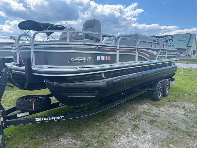 Slide: The Image of 2022 Ranger 220 F pontoon boat on trailer, parked on grass under a cloudy sky. - 6