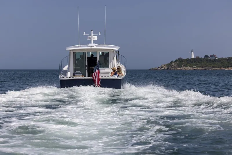 Slide: The Image of Back Cove 412 (2026) cruising near a lighthouse on a clear day. - 3