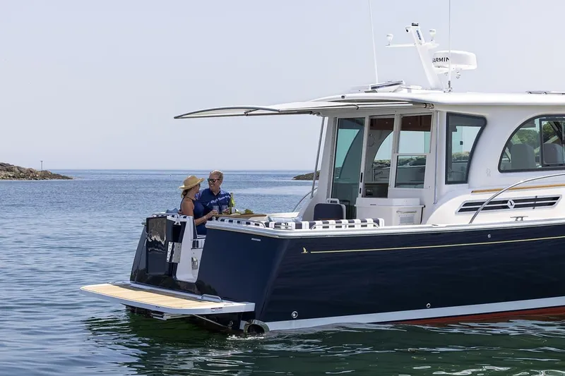 Slide: The Image of 2026 Back Cove 412 yacht on water, two people enjoying the deck. - 4