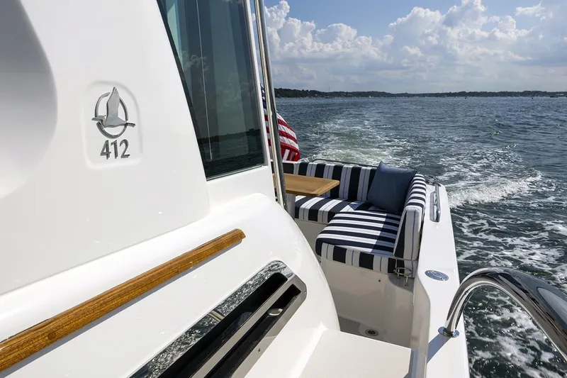 Slide: The Image of 2026 Back Cove 412 yacht with striped seating, cruising on a sunny day. - 5