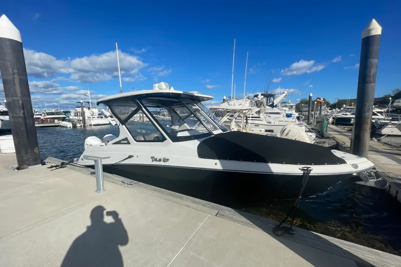 The Image of 2022 Finseeker 280 DC boat docked at marina under clear blue sky. - 0