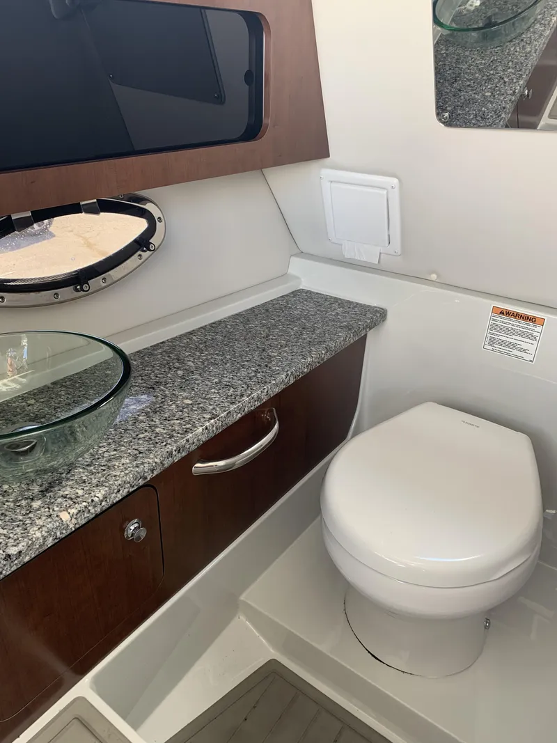 Slide: The Image of 2022 Finseeker 280 DC boat interior with seating and storage, docked at marina. - 16