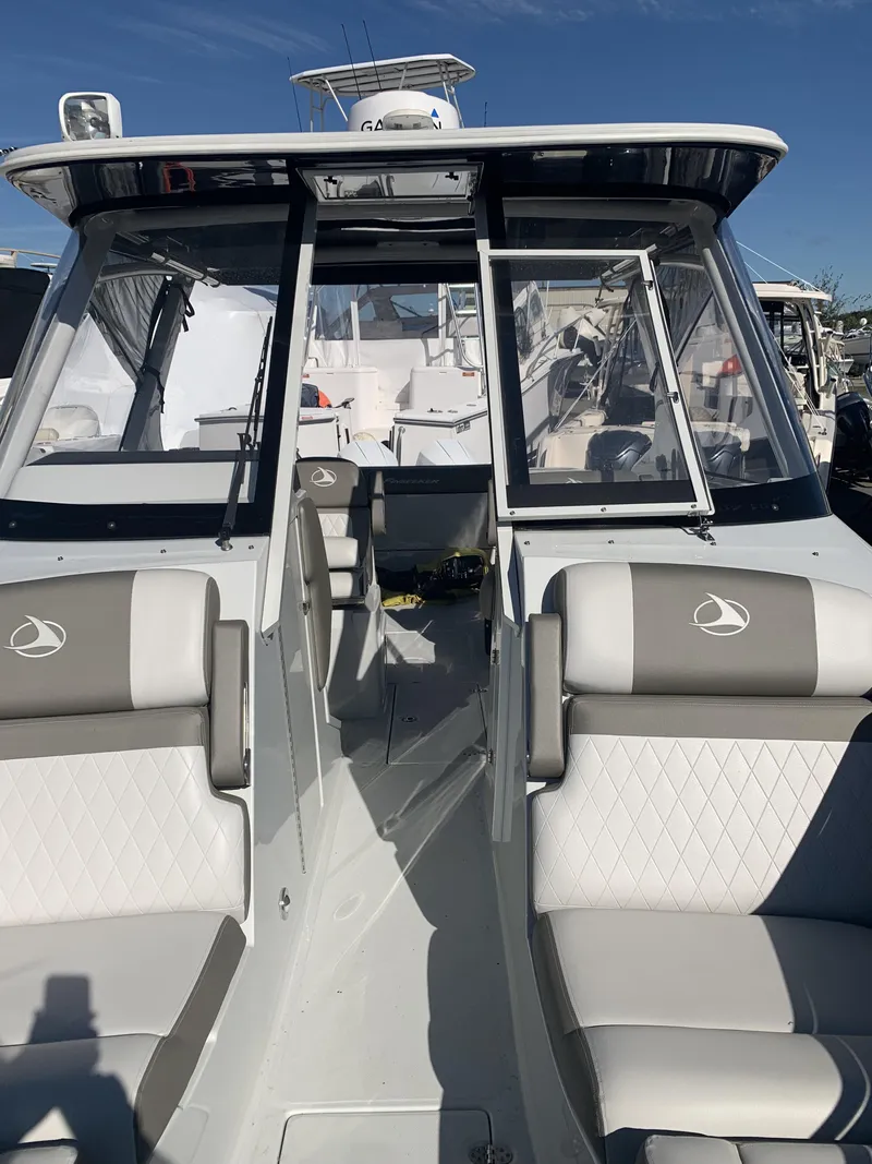 Slide: The Image of 2022 Finseeker 280 DC boat interior with seating and helm, under clear blue sky. - 19