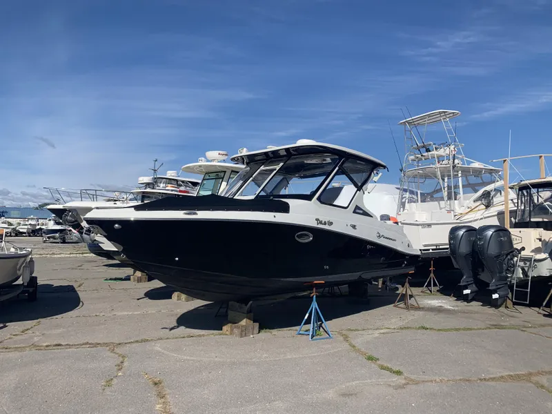 Slide: The Image of 2022 Finseeker 280 DC boat docked with Mercury engines, clear sky background. - 2