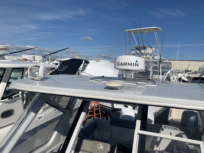 Slide: The Image of 2022 Finseeker 280 DC boat docked at marina under clear blue sky. - 5