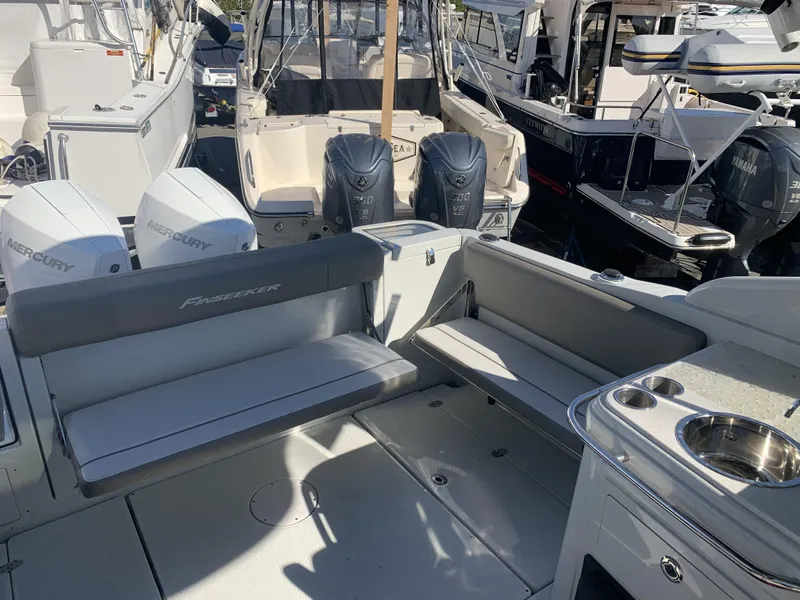 Slide: The Image of 2022 Finseeker 280 DC boat docked with twin Mercury engines, sunny marina setting. - 7