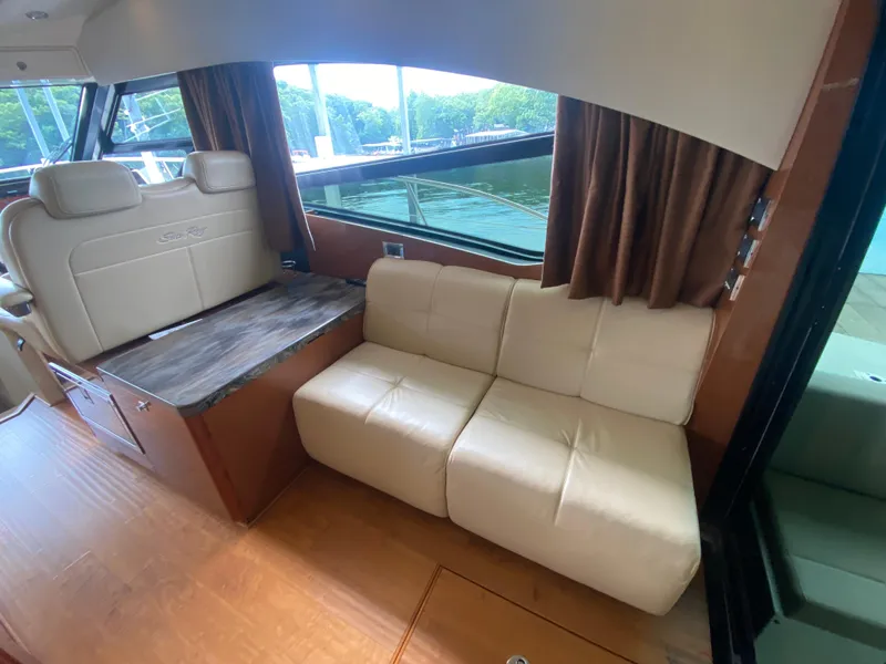 Slide: The Image of Interior of 2015 Sea Ray 470 Sundancer yacht with beige seating and wooden accents. - 17