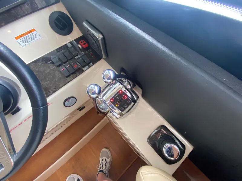 Slide: The Image of Control panel of a 2015 Sea Ray 470 Sundancer yacht, featuring steering and throttle controls. - 25