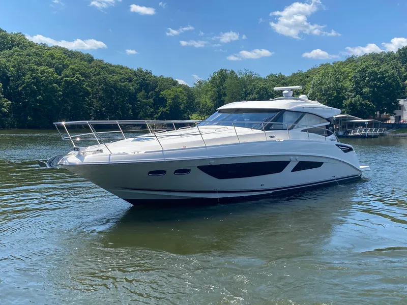 Slide: The Image of 2015 Sea Ray 470 Sundancer yacht on a serene lake with lush green trees. - 3