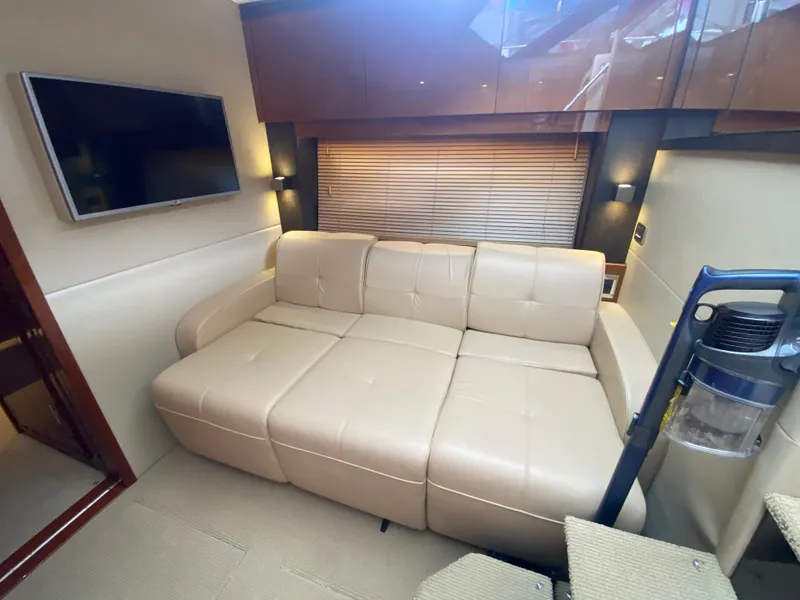 Slide: The Image of Luxurious interior of 2015 Sea Ray 470 Sundancer with beige leather sofa and wall-mounted TV. - 30