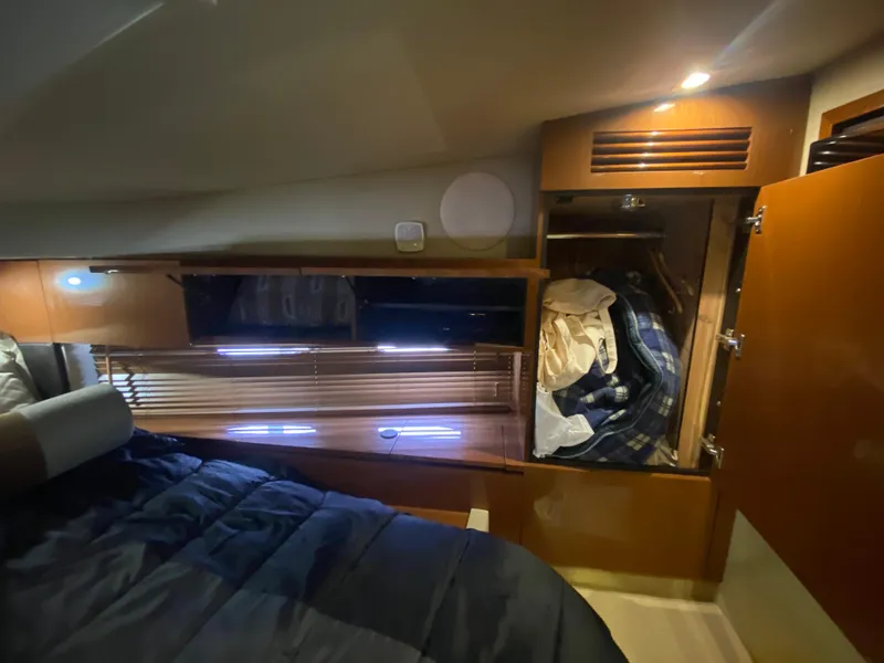 Slide: The Image of 2015 Sea Ray 470 Sundancer cabin interior with bed, closet, and ambient lighting. - 36