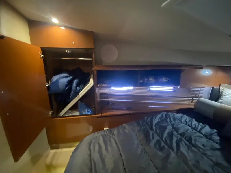 Slide: The Image of 2015 Sea Ray 470 Sundancer cabin interior with open closet and bedding. - 37