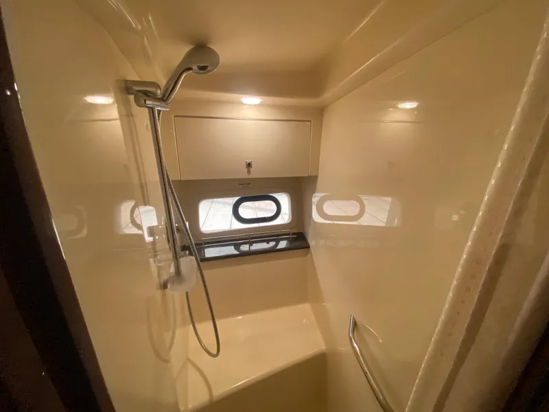 Slide: The Image of Shower area in 2015 Sea Ray 470 Sundancer yacht, featuring modern fixtures and porthole windows. - 39