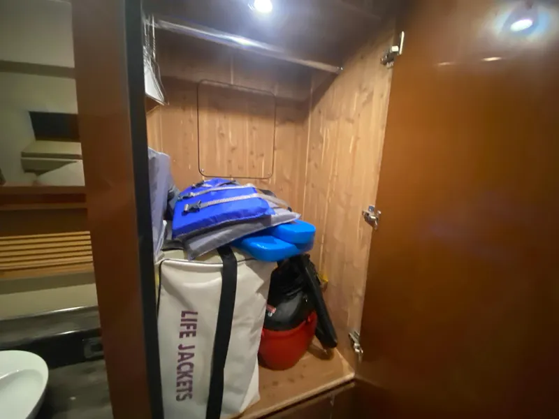Slide: The Image of Storage closet on 2015 Sea Ray 470 Sundancer with life jackets and boating gear. - 45