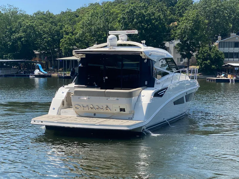 Slide: The Image of 2015 Sea Ray 470 Sundancer yacht on a sunny lake, surrounded by trees and docks. - 7