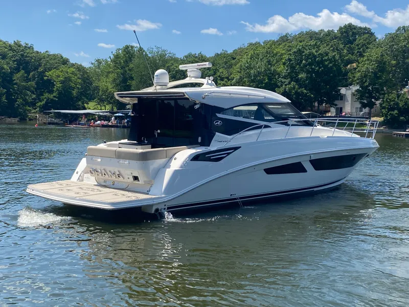 Slide: The Image of 2015 Sea Ray 470 Sundancer yacht cruising on a serene lake with lush green surroundings. - 8