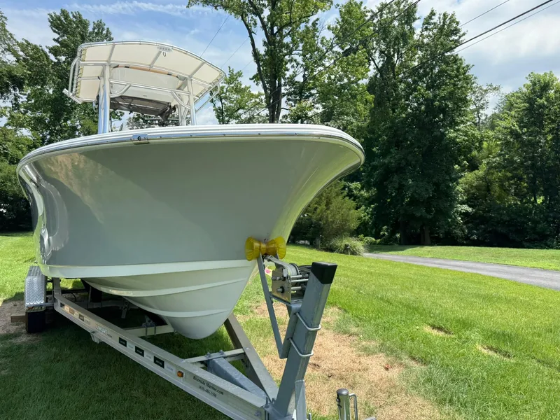Slide: The Image of 2019 Sportsman Open 232 Center Console boat on trailer, parked on grass. - 3