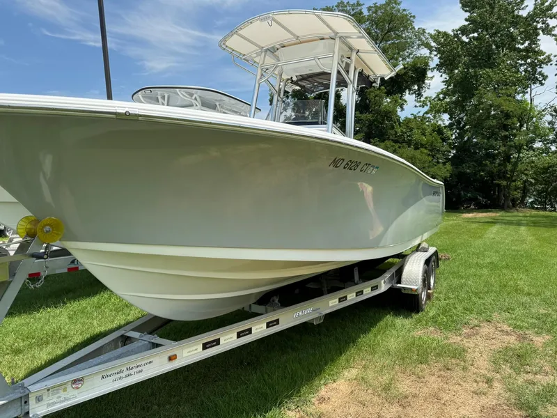 Slide: The Image of 2019 Sportsman Open 232 Center Console boat on trailer, parked on grass. - 5