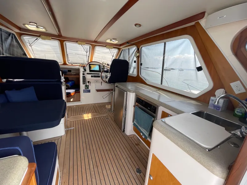 Slide: The Image of Interior of a 2007 True North 38 boat with seating, helm, and kitchenette. - 12