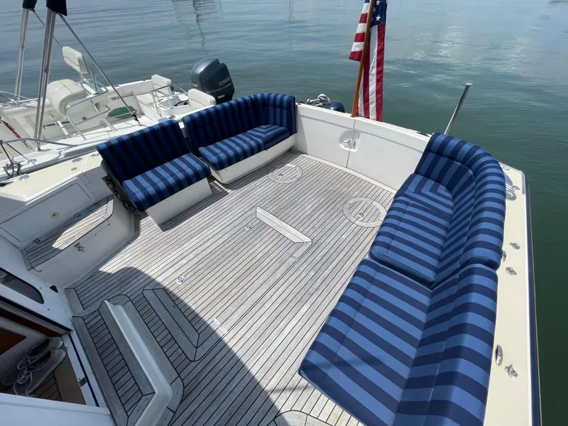 Slide: The Image of Spacious deck of 2007 True North 38 boat with striped seating and American flag. - 6