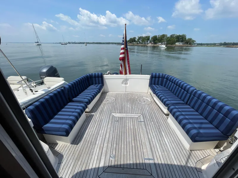Slide: The Image of 2007 True North 38 boat deck with striped seating, American flag, and scenic water view. - 7