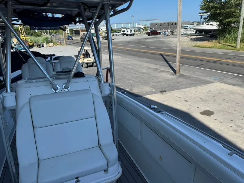 Slide: The Image of 1998 Wellcraft Scarab Sport 302 boat interior at a marina, showing seating and dockside view. - 28