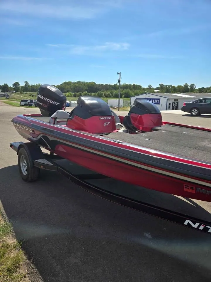 Slide: The Image of 2011 Nitro Z-7 boat with Mercury engine on trailer, parked outdoors under clear sky. - 2
