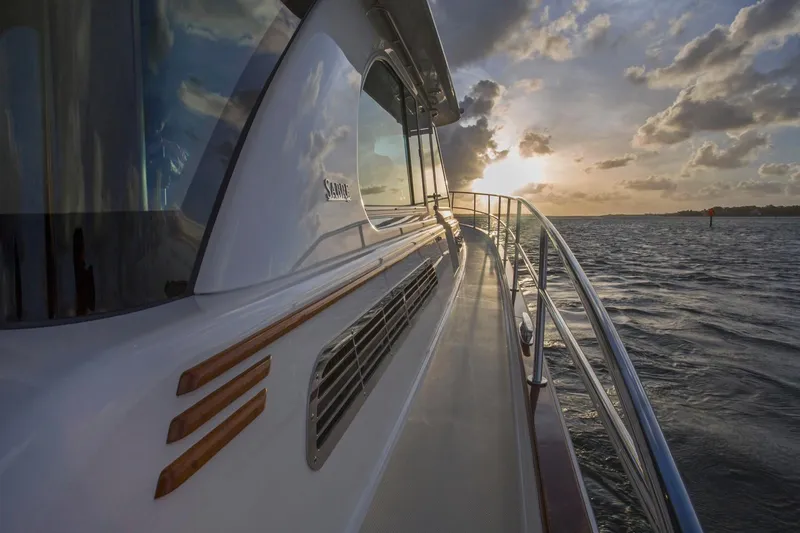 Slide: The Image of 2026 Sabre 45 Salon Express yacht with American flag, elegant interior, and scenic water view. - 5