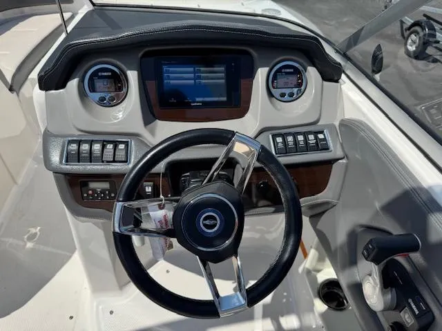 Slide: The Image of 2017 Chaparral 250 Suncoast boat dashboard with steering wheel and control panel. - 11