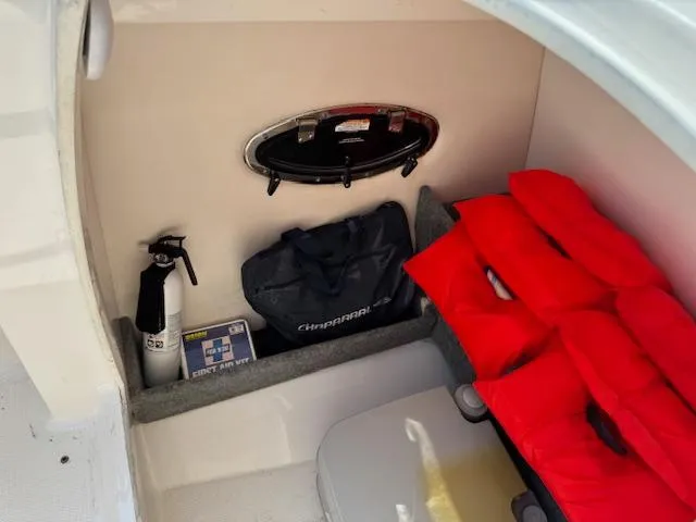 Slide: The Image of 2017 Chaparral 250 Suncoast interior with safety gear, fire extinguisher, and life jackets. - 15