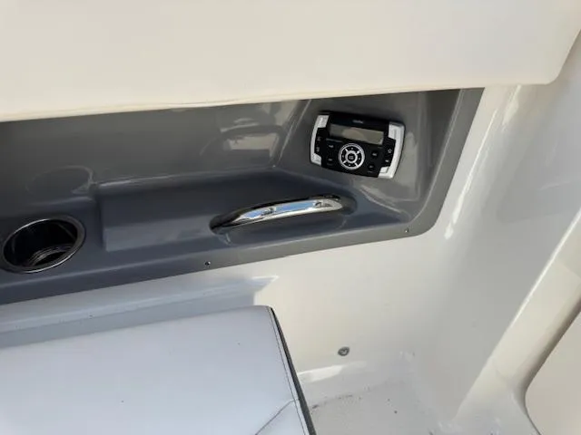 Slide: The Image of Interior detail of 2017 Chaparral 250 Suncoast boat, featuring a control panel and cup holder. - 18