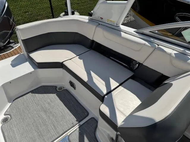 Slide: The Image of 2017 Chaparral 250 Suncoast boat interior with cushioned seating and gray flooring. - 20
