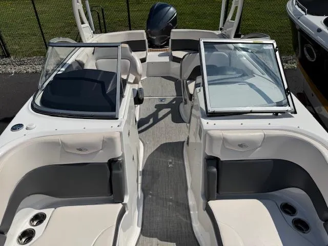 Slide: The Image of 2017 Chaparral 250 Suncoast boat interior with seating and windshield, parked outdoors. - 8