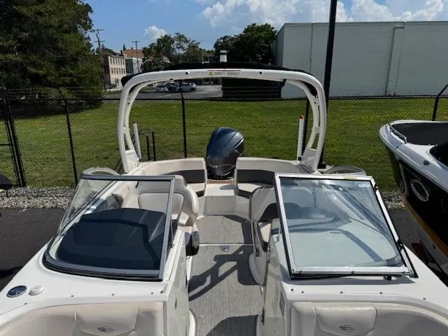 Slide: The Image of 2017 Chaparral 250 Suncoast boat with open cockpit and seating, parked outdoors. - 9