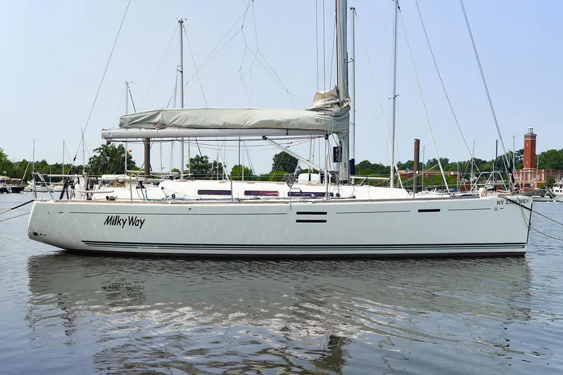 Slide: The Image of 2011 Dufour 40E Performance sailboat named "Milky Way" docked on calm water. - 13